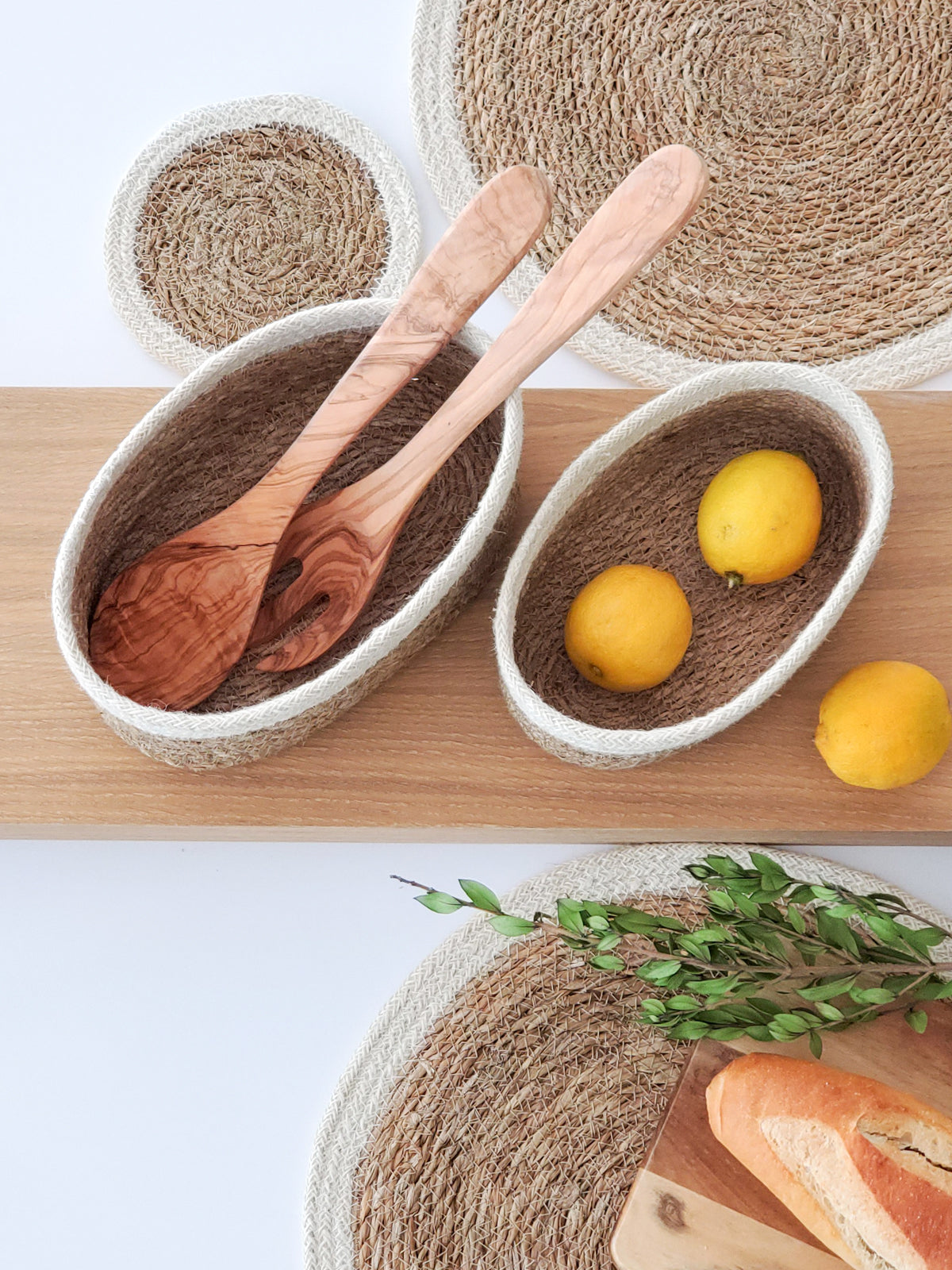 Korissa Savar Oval Bowl with wooden spoons, woven placemats, lemons