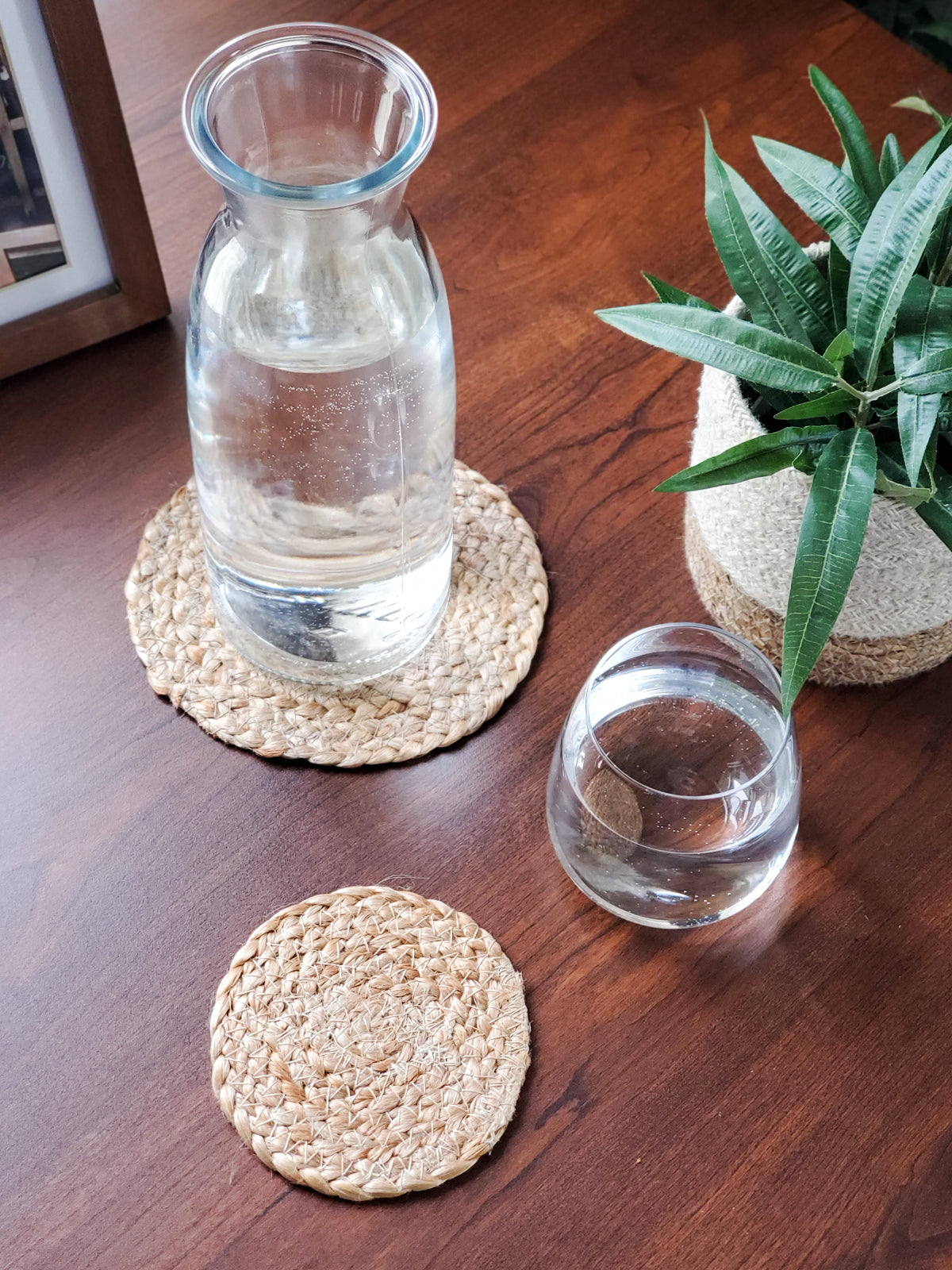 Korissa Kata Natural Drink Coaster under water carafe and glasses, wood table