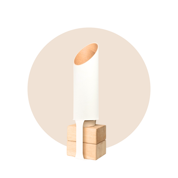 Minimalist matte-white cylindrical yoga mat tube with an angled opening and warm kraft-paper interior, standing on four pale wood blocks.