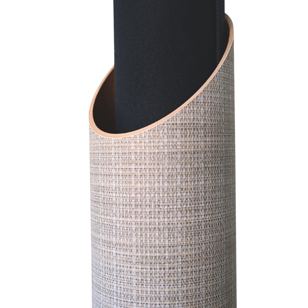 Close-up of a rolled black yoga mat inserted into the tube’s slanted opening, highlighting the fine crosswoven surface.