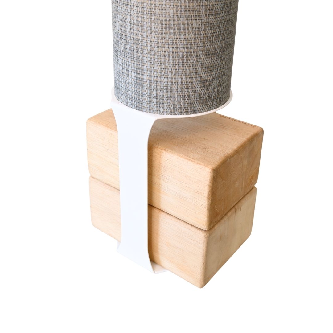 Close-up of the tube mounted above four pale wood blocks with a contrasting white support strap.