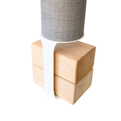 Close-up of the tube mounted above four pale wood blocks with a contrasting white support strap.