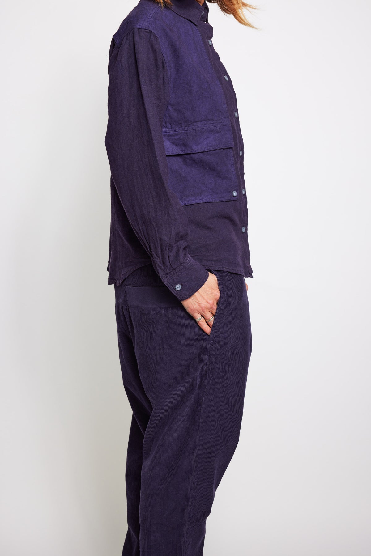 Close side view of the navy Trek Shirt and its layered utility pockets.
