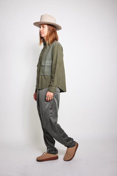 Side view of the olive Trek Shirt worn with gray pants and brown shoes.