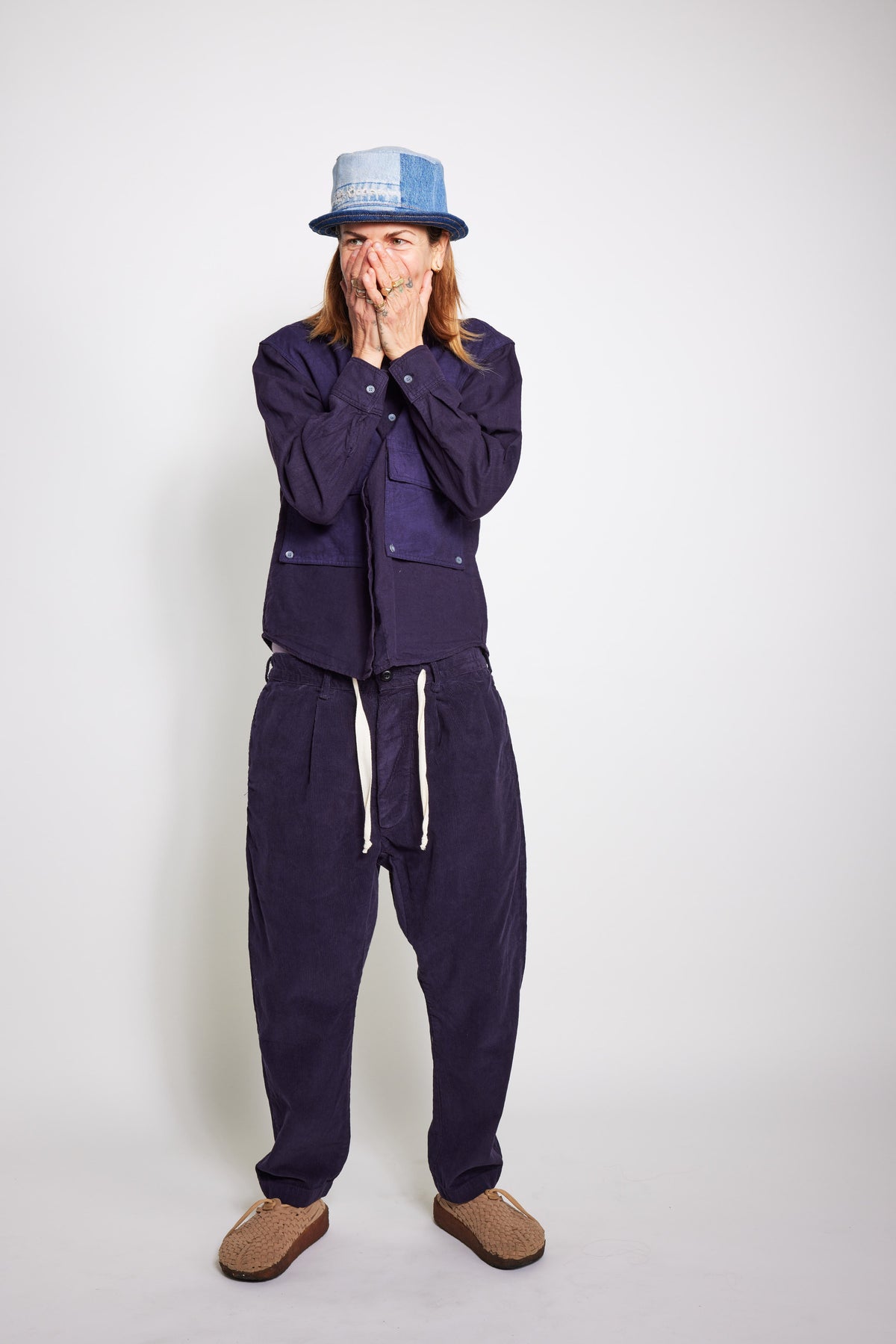 Model wearing the navy Trek Shirt and matching pants with hands raised near the face.