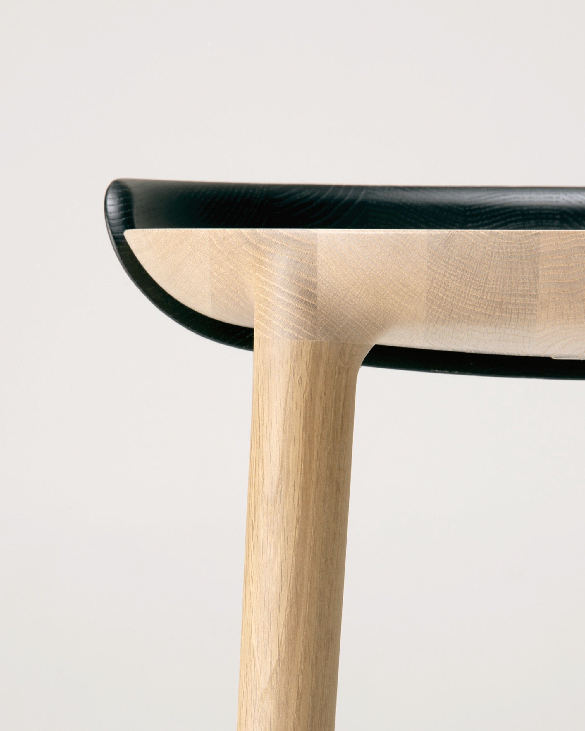 Side profile of CRUST coffee table showing elliptical Japanese Oak top and contrasting leg — modern Japandi furniture by CondeHouse.