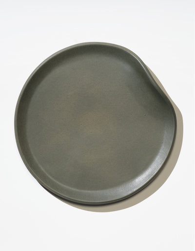 Tortuga Forma Dinner Plate Single in Liche viewed overhead on white, showing its gently irregular outline, low curved rim and finely textured centre.