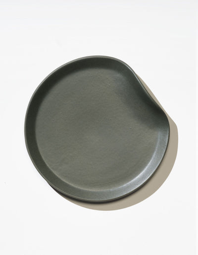 Tortuga Forma Salad Plate Single in Liche viewed overhead on white, showing its asymmetrical outline, curved raised rim and finely textured centre.