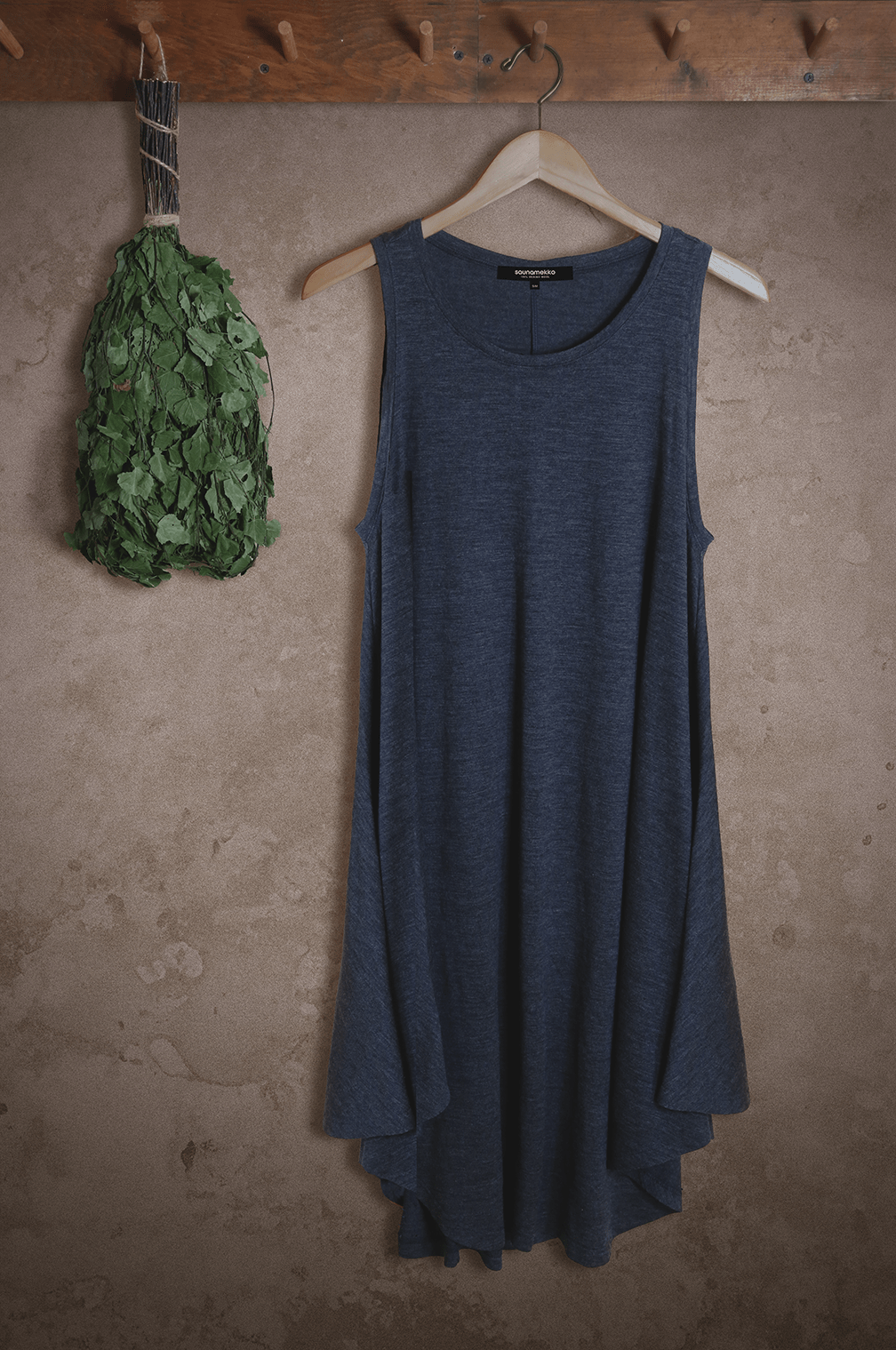 Merino wool sauna dress hanging on wall showcasing minimalist design and breathable natural wool construction.