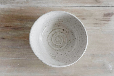 Top view speckled handmade earthenware cereal bowl with spiral texture