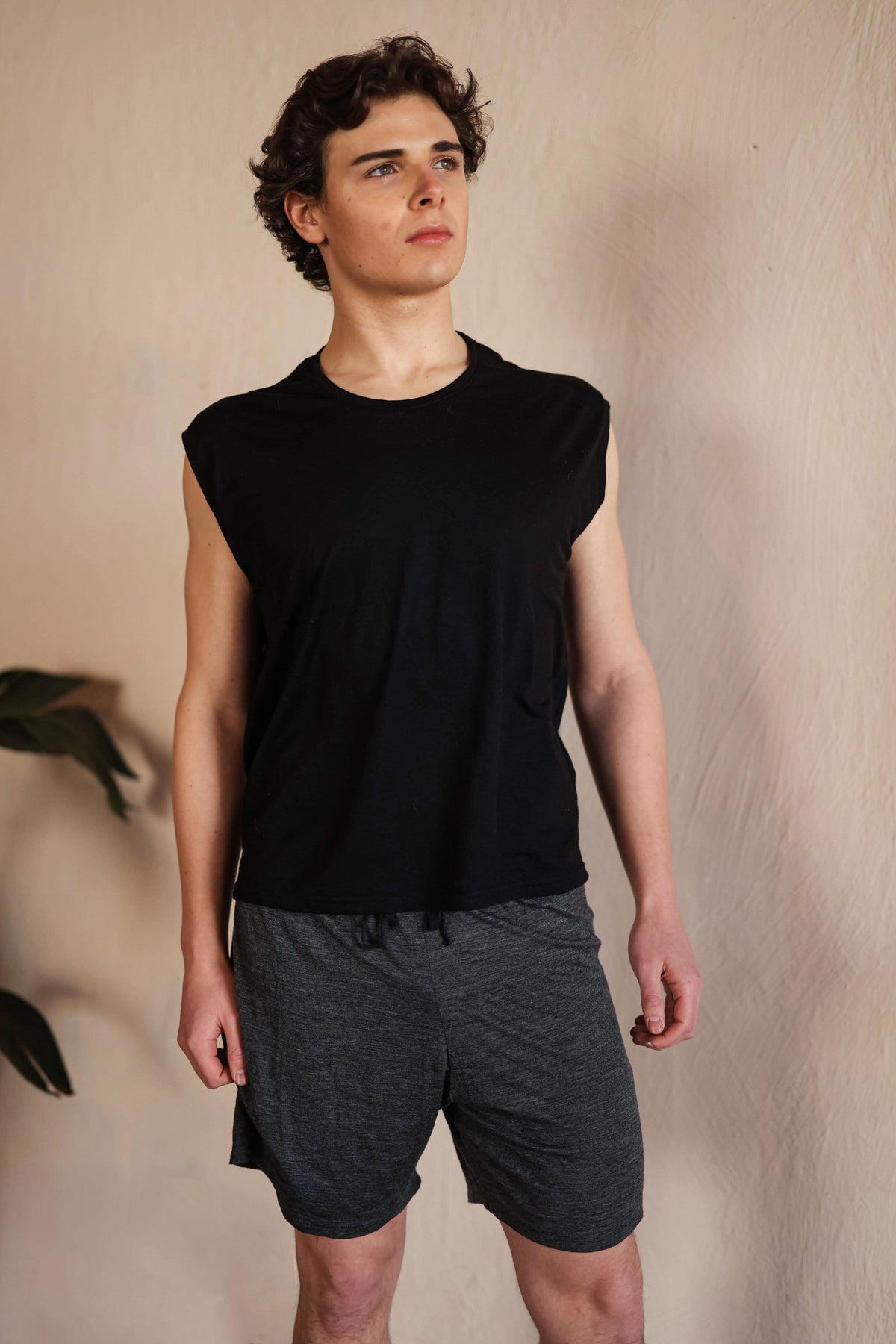 Model wearing men's merino wool sauna shorts and black merino tee designed for sauna, cold plunge, and wellness rituals.