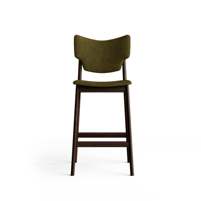 Front view of the olive-green Eikund Veng Bar Stool, showing its wing-shaped upholstered back, slim padded seat, open gap above the seat, and wood footrest.