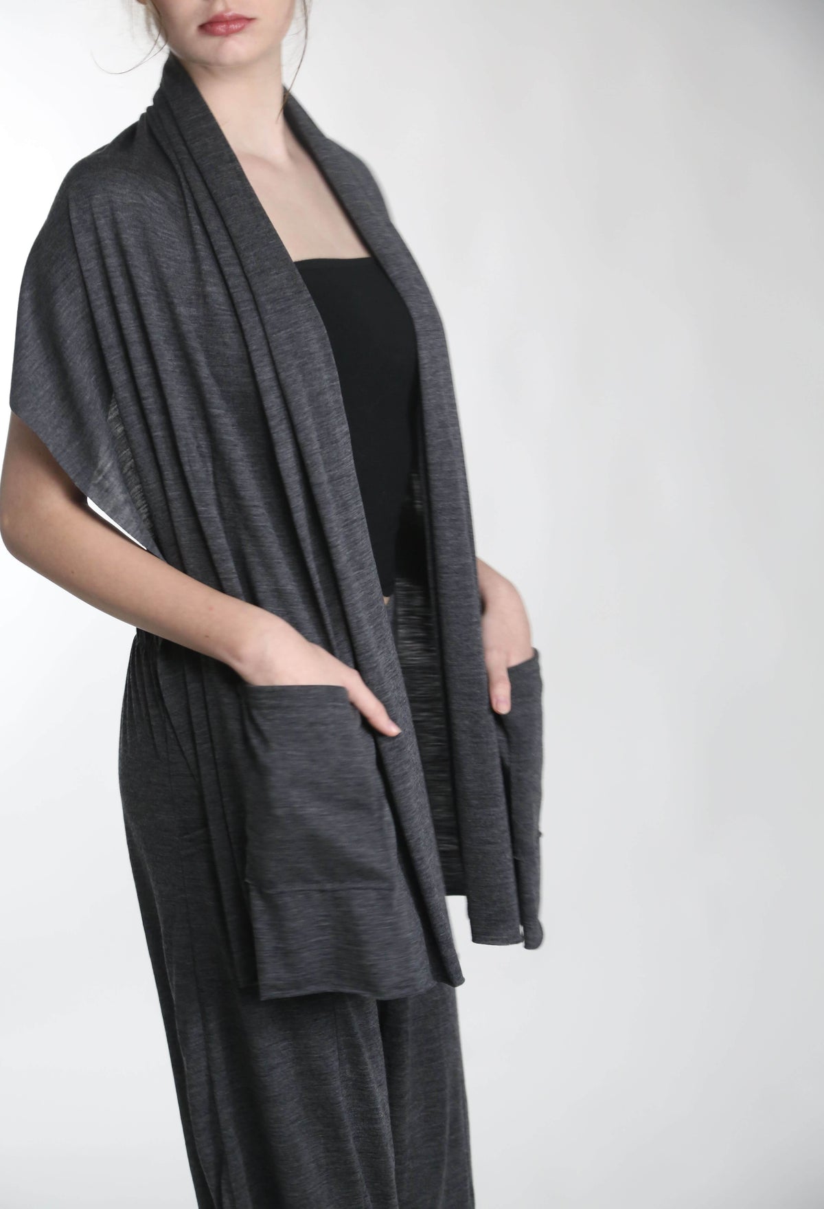 Merino wool pocket wrap worn as a shawl layer, combining warmth, breathability, and minimalist design.