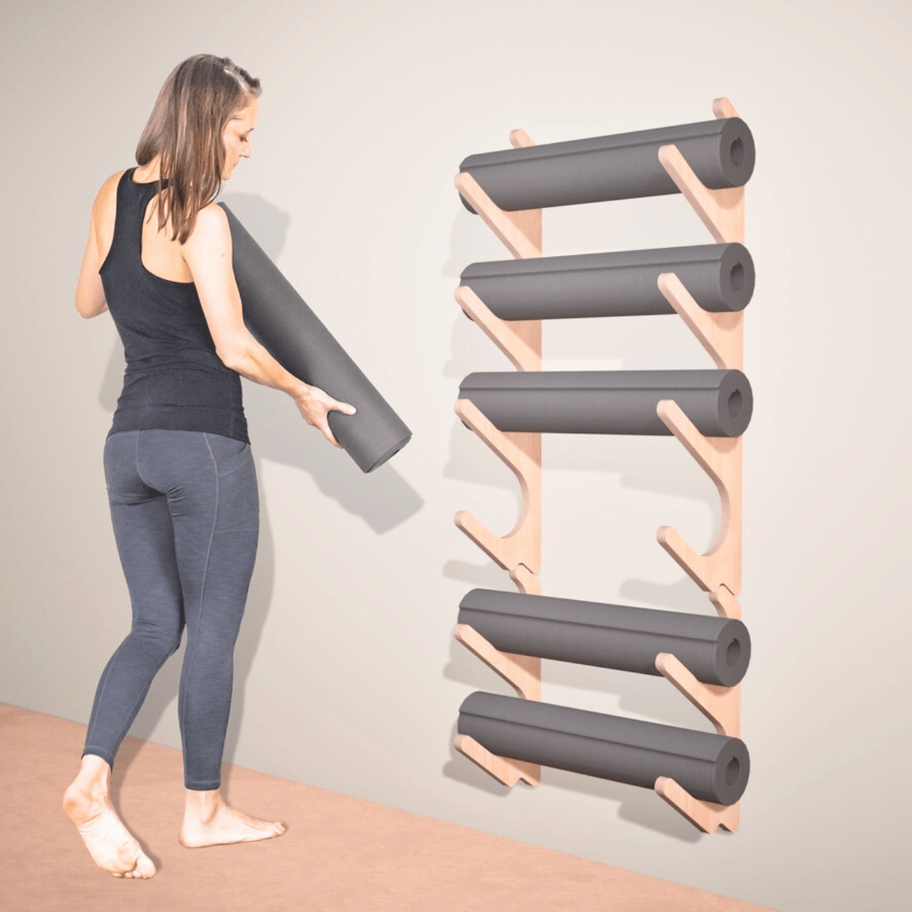 Wall-mounted yoga prop organizer holding rolled yoga mats