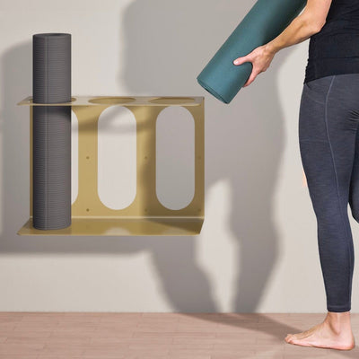 Gold three-slot bracket holding a gray roller while a person positions a teal roller above another opening.