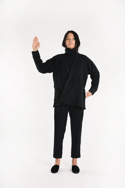 Model posing in black Souk pants with a matching black top.
