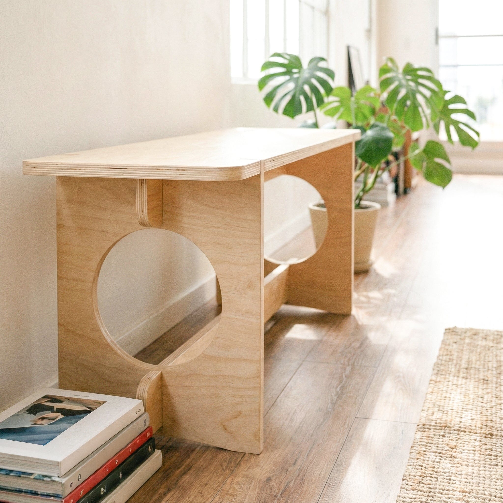 Close-up of the YOYO bench highlighting its thick wood seat, layered plywood edges, circular side openings and lower support rail