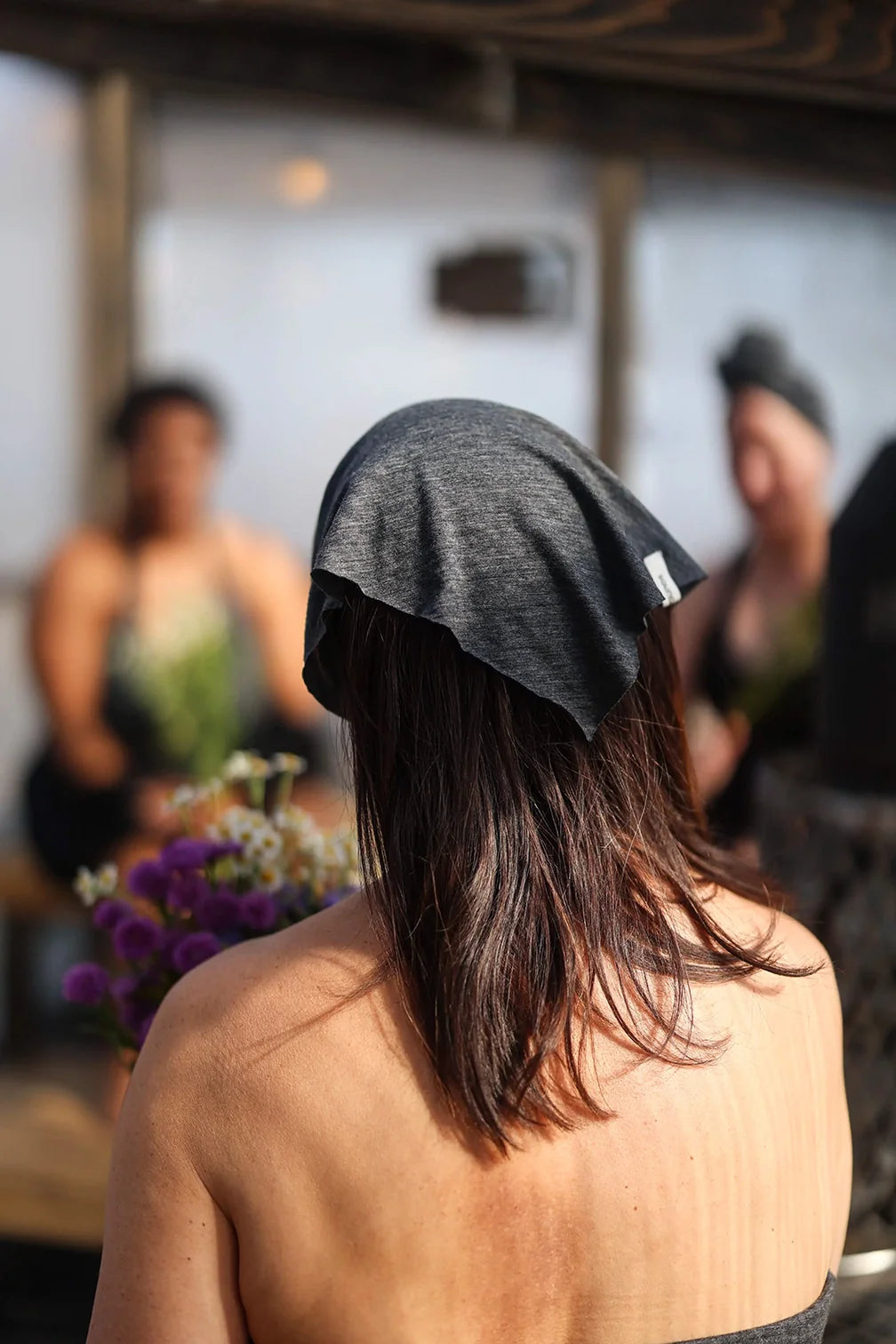 Merino wool bandana worn as a lightweight head covering during sauna and wellness rituals.