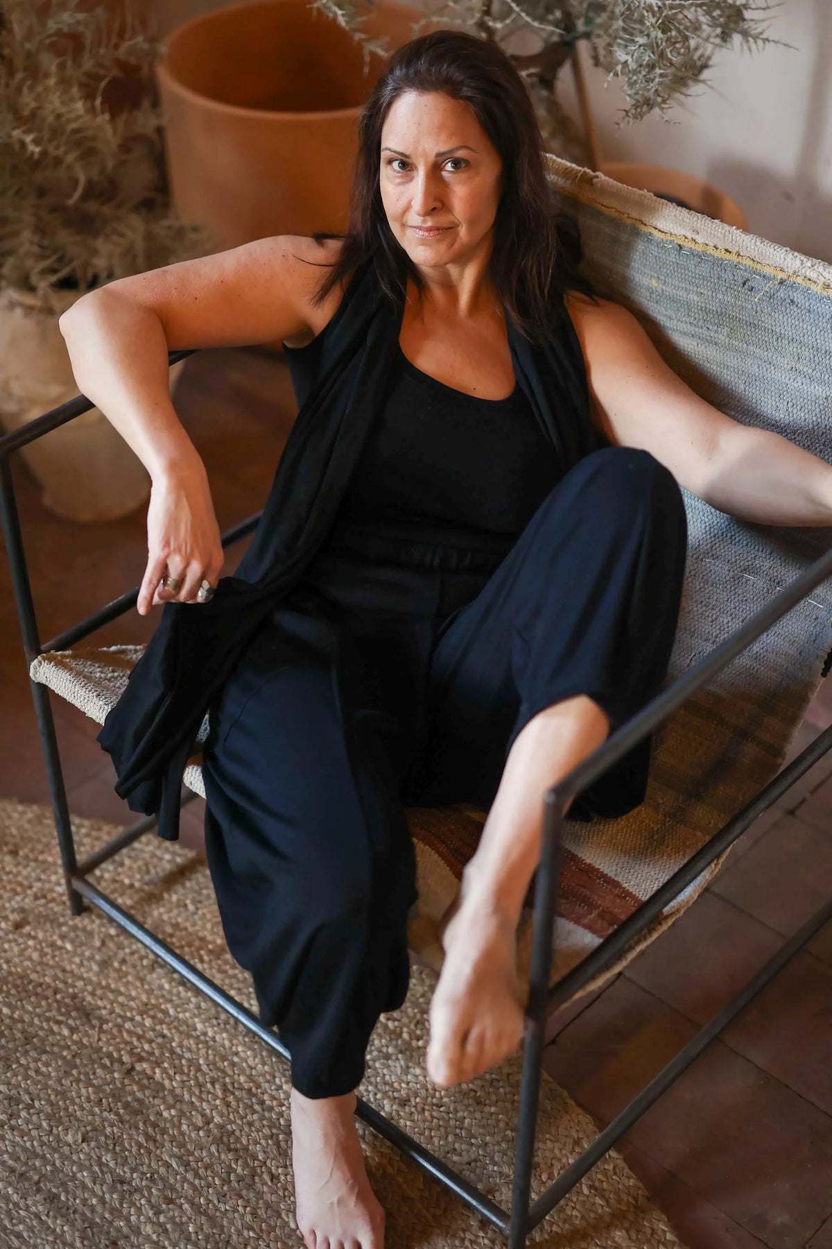 Woman wearing a merino wool sauna tank while relaxing after a sauna session, highlighting softness, breathability, and everyday versatility.