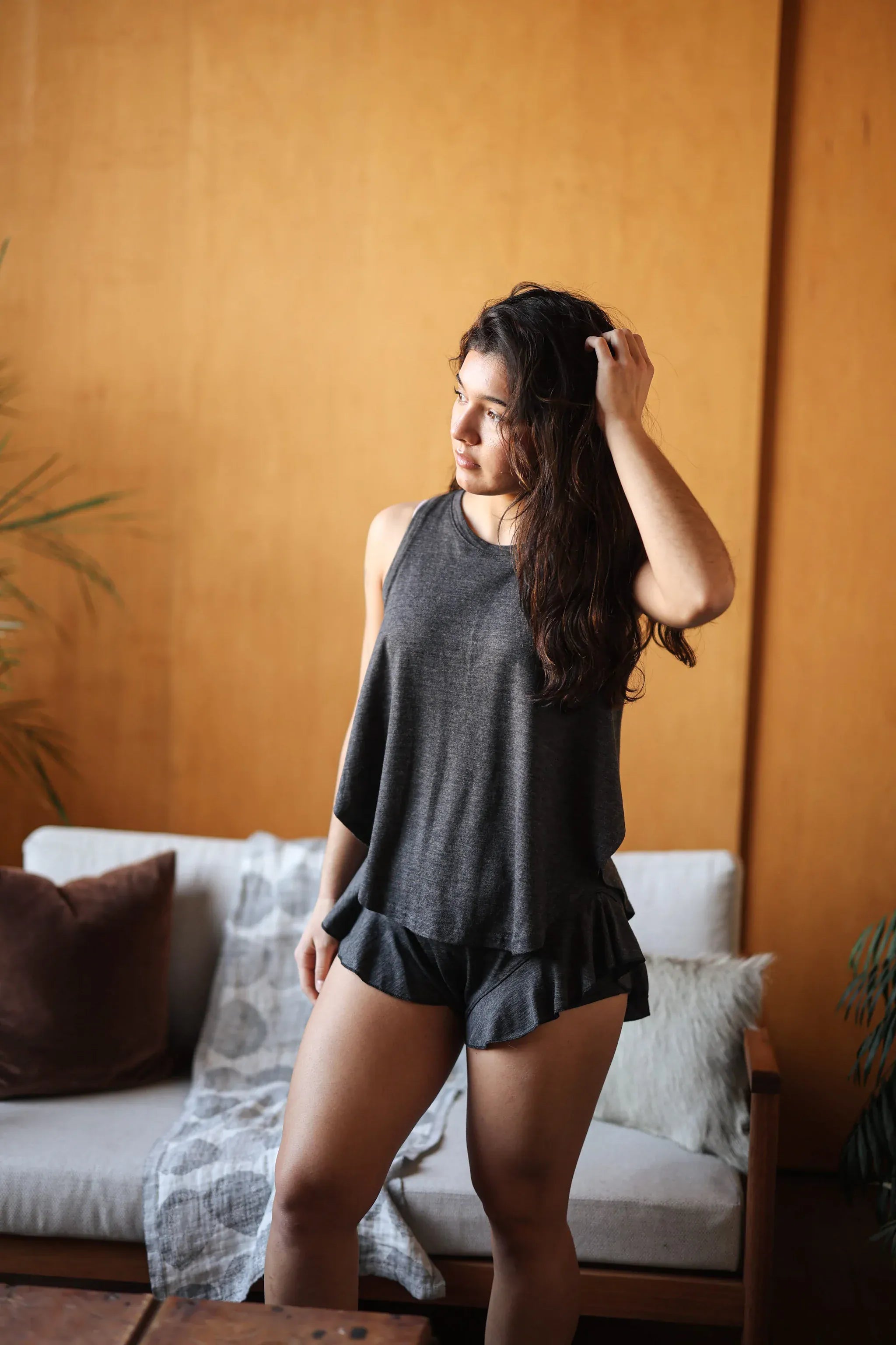 Woman wearing merino wool sauna shorties designed for sauna recovery, sleep, lounging, and everyday comfort.