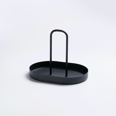 Empty black Yamazaki Home Vanity Tray with Handle - Steel on a pale background, viewed from above at an angle to show its oval base, raised edge and upright loop handle.