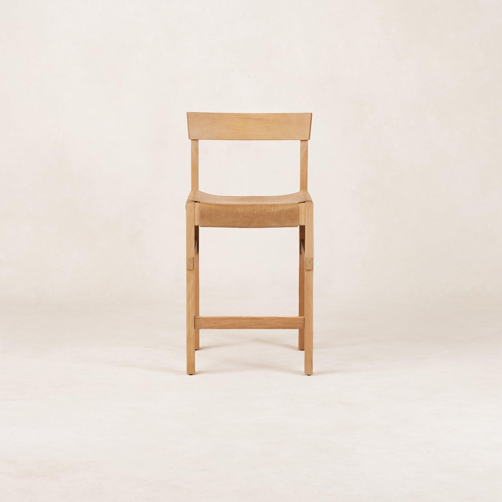A beige Shinto Counter Stool with a leather seat and wooden frame, inspired by the Torii Gate from Japanese Shinto shrines.