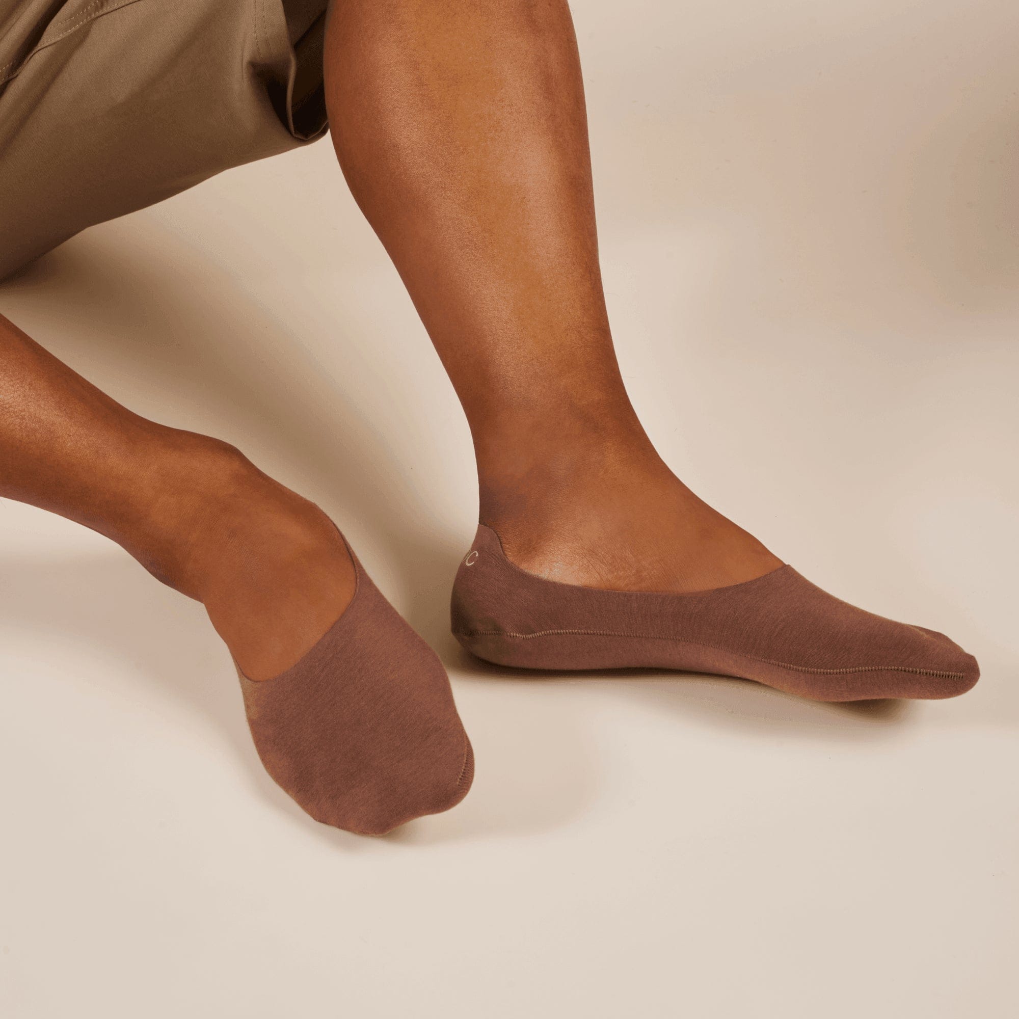 Brown socks worn by a person on a beige background