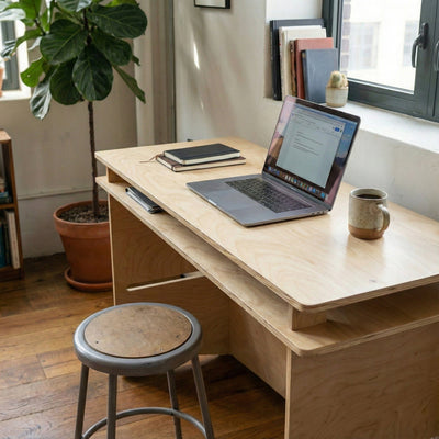 Elevated view of the Williamsburg desk with an open laptop and mug, highlighting the layered desktop and pale natural wood grain