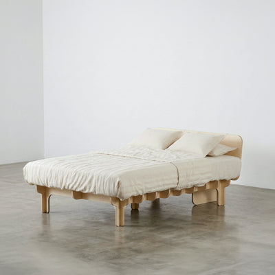 Medium-width DOVID wood bed frame with white bedding, shown from the front-left to display its platform and support legs
