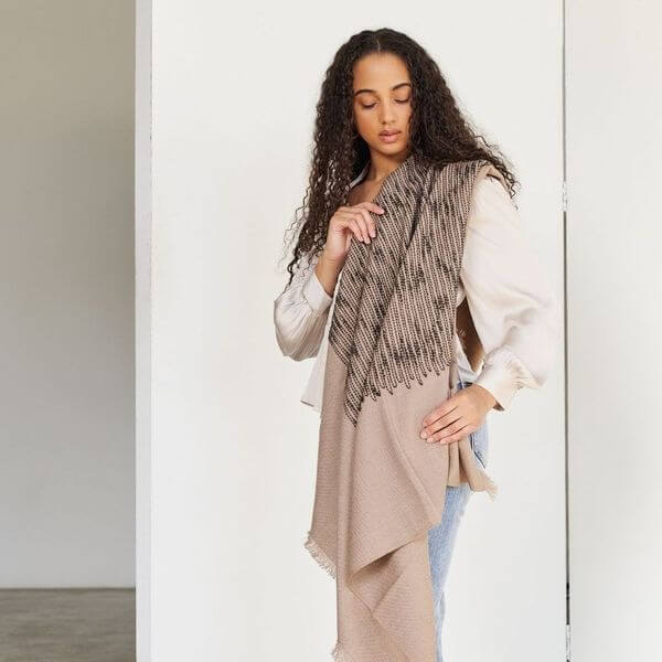 Woman wearing the Flo Brown handloom throw around her shoulders with the dark textured panel across the front