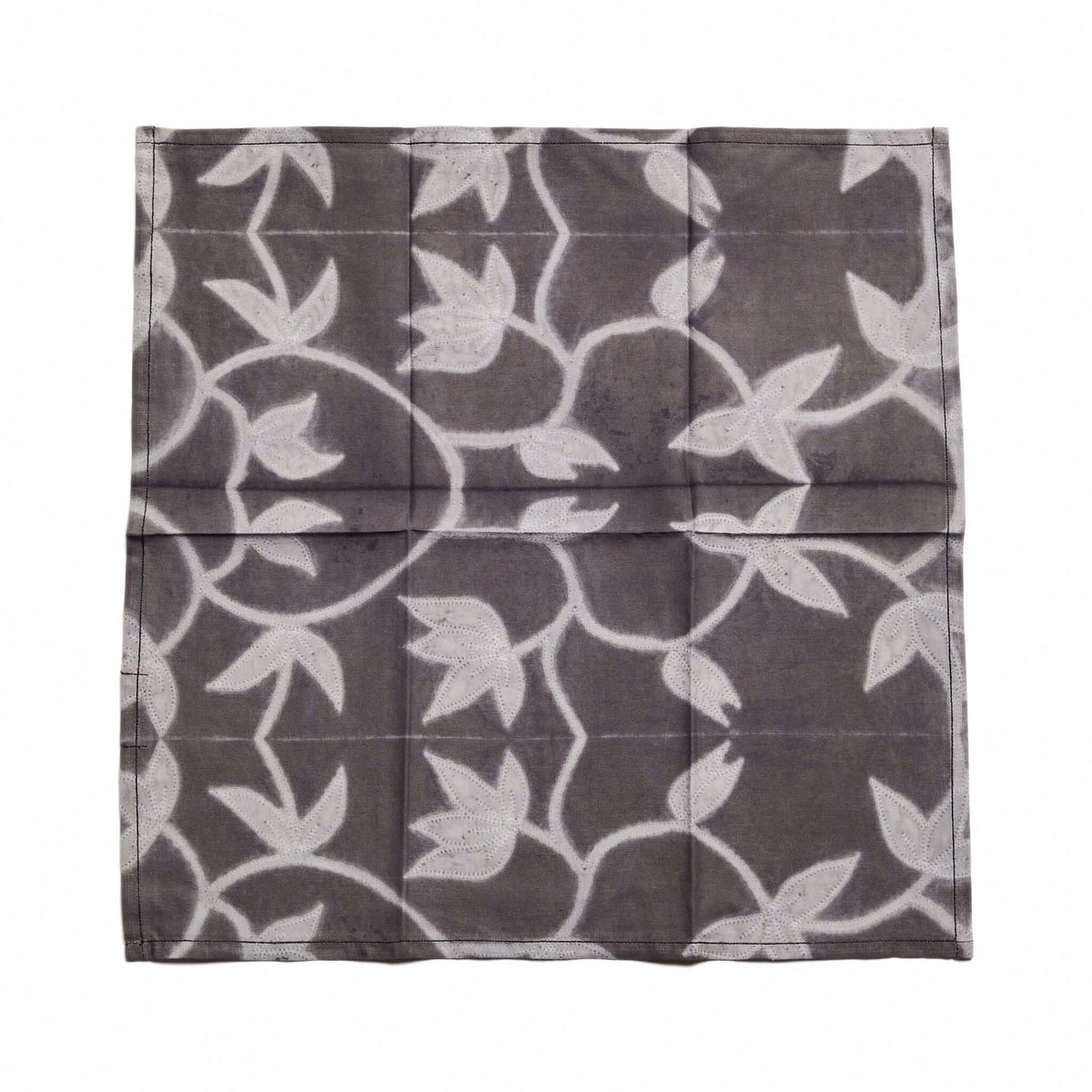 Four Folio Black handcrafted cotton napkins folded into a square stack against a white background