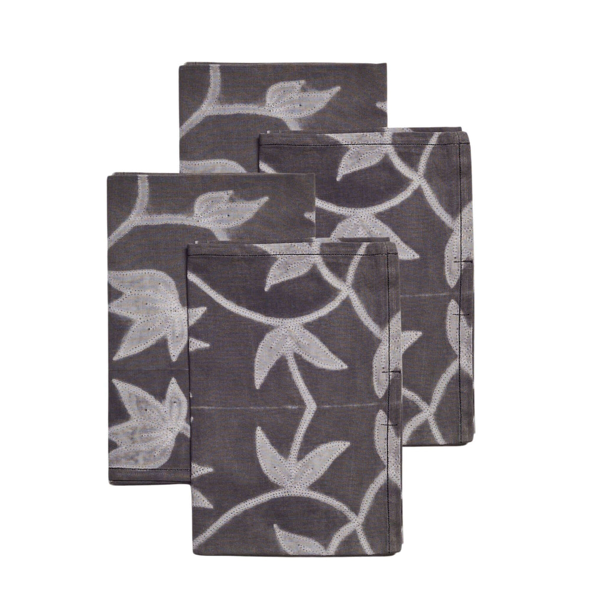 Set of four Folio Black cotton table napkins arranged in an overlapping stack to display the handcrafted botanical shibori print