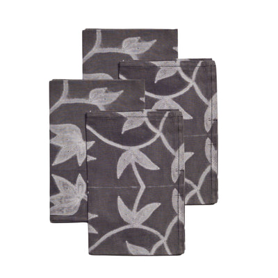 Set of four Folio Black cotton table napkins arranged in an overlapping stack to display the handcrafted botanical shibori print