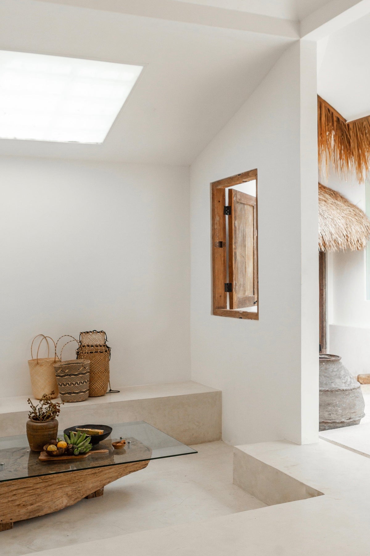 Village Thrive Praya Day Bag, natural rattan, displayed in a bright white interior room.