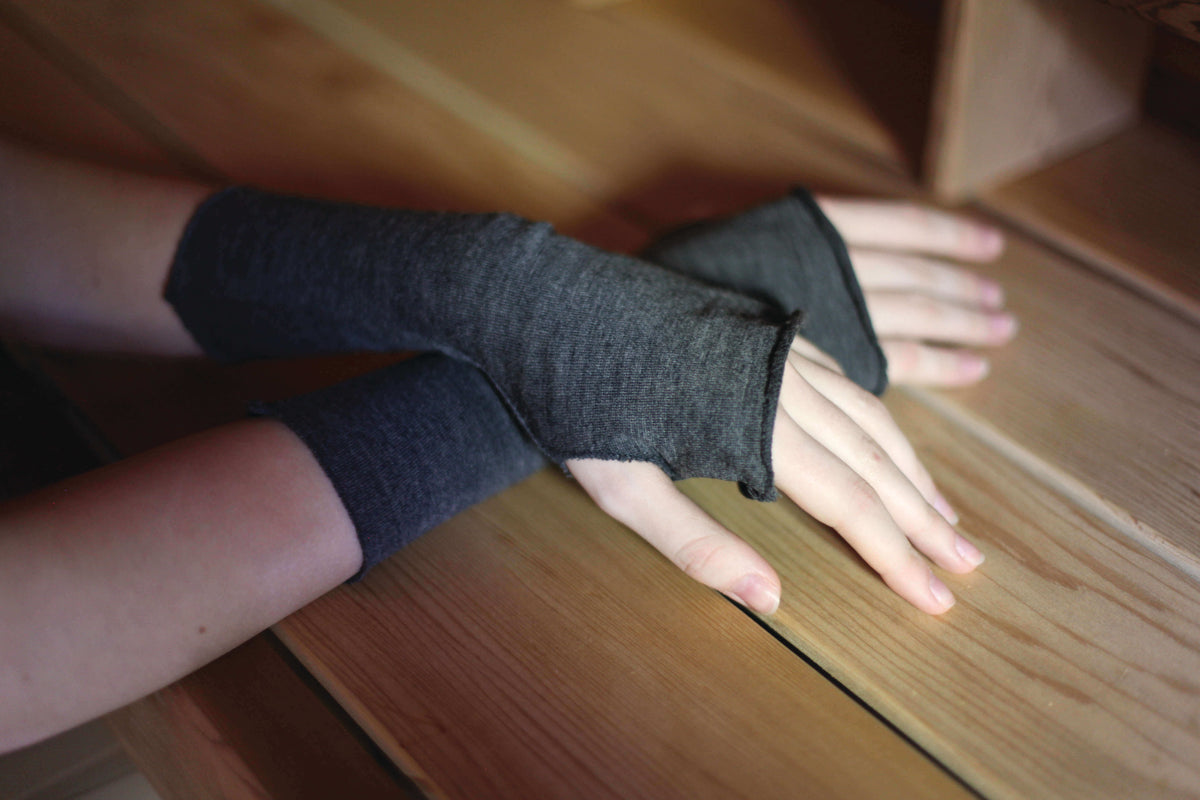 Close-up of charcoal merino wool fingerless gloves showcasing soft natural wool fabric and open-finger design.