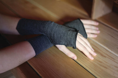 Close-up of charcoal merino wool fingerless gloves showcasing soft natural wool fabric and open-finger design.