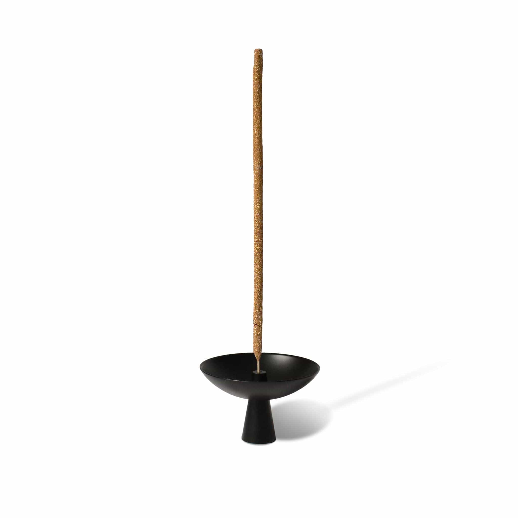 Black incense holder with a single incense stick on a white background
