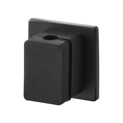 Black Yamazaki Home Magnetic Cable Holder With Adhesive Steel Base - Silicone shown at an angle on white, revealing its rectangular body, circular cable opening and square backing plate.