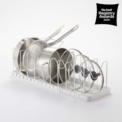 White Yamazaki Home Adjustable Pot Lid Organizer - Steel holding upright frying pans, saucepans and glass lids between wire dividers; a black badge reads The Knot Registry Awards 2026.