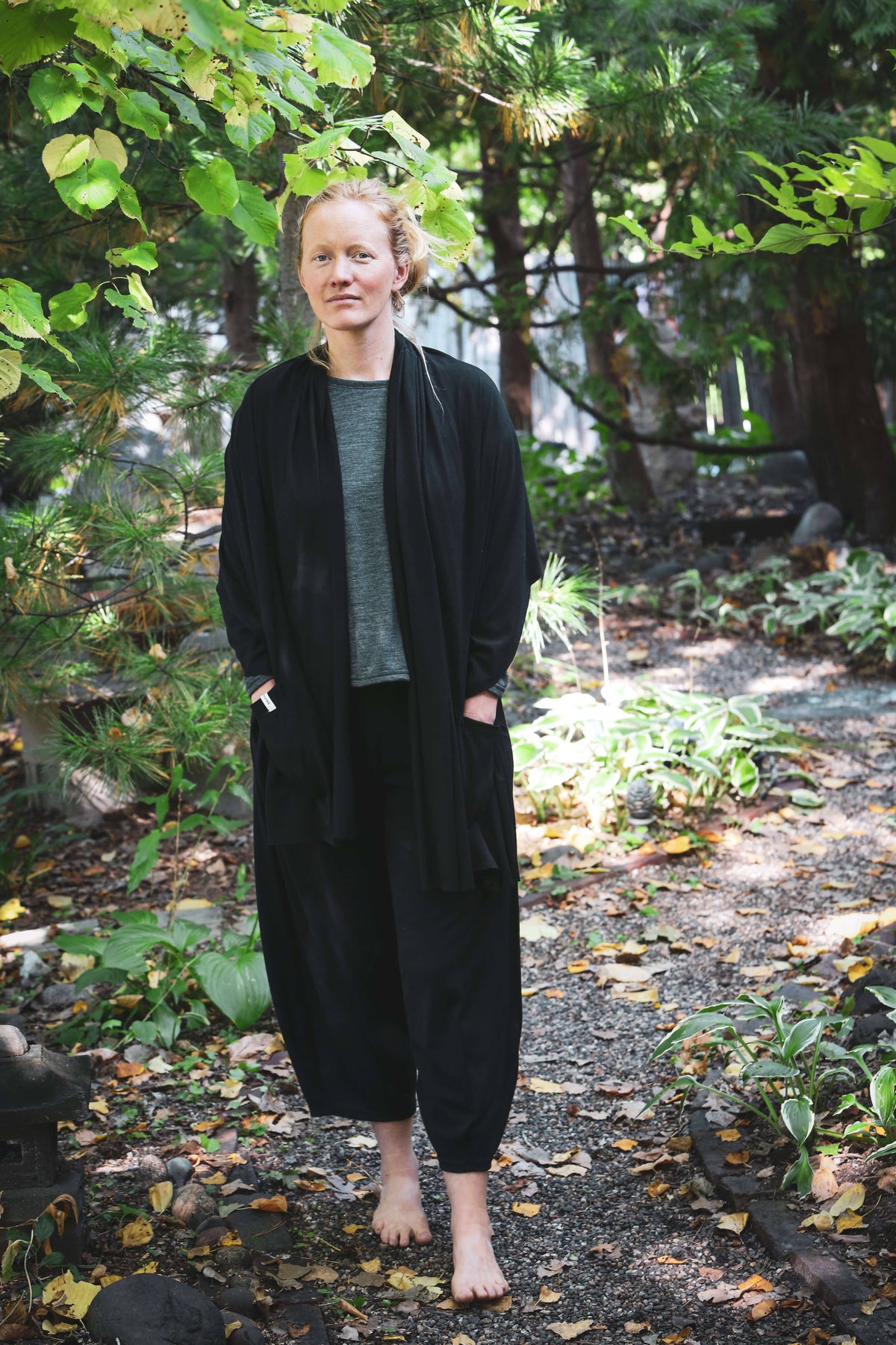 Woman wearing black merino wool lounge pants outdoors, showcasing a relaxed silhouette and natural wool comfort.