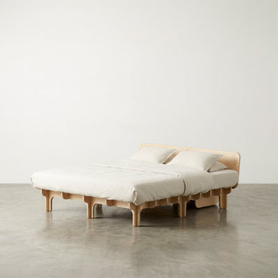 Extra-wide DOVID wood bed frame with white bedding and two pillows, shown from the front-left against a neutral studio background