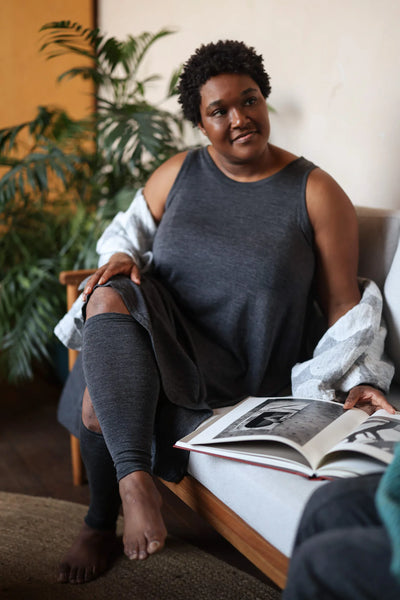 Merino wool leg warmers worn while relaxing indoors, providing lightweight warmth and breathable natural comfort.