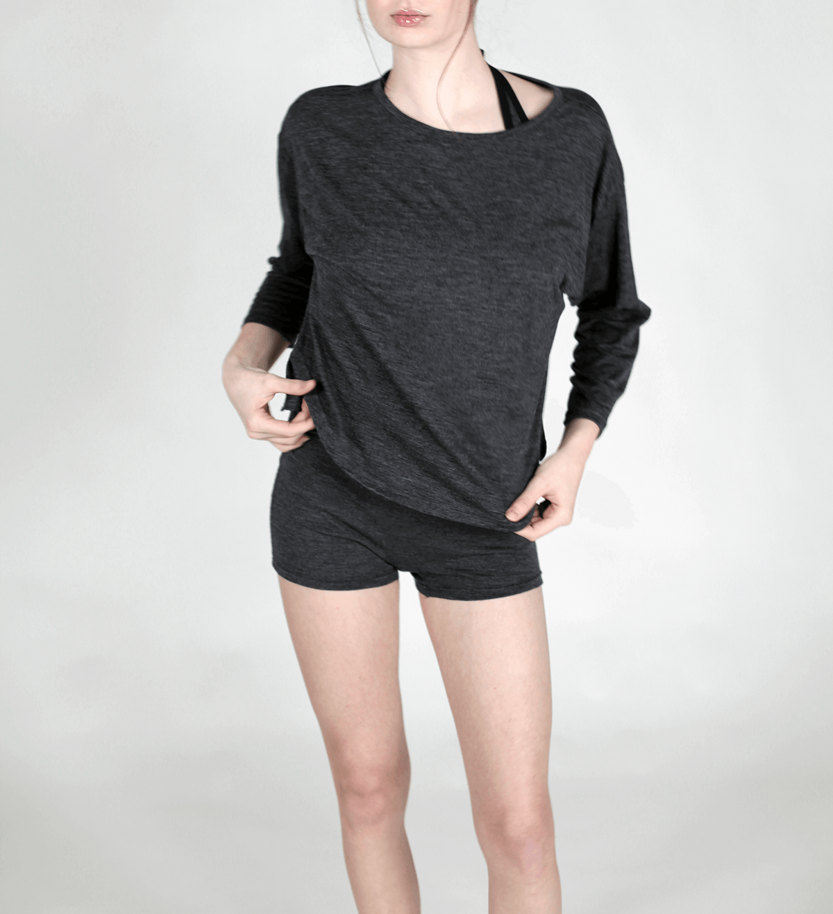 Woman wearing a charcoal merino wool lounge top featuring a relaxed silhouette, breathable comfort, and natural wool softness.