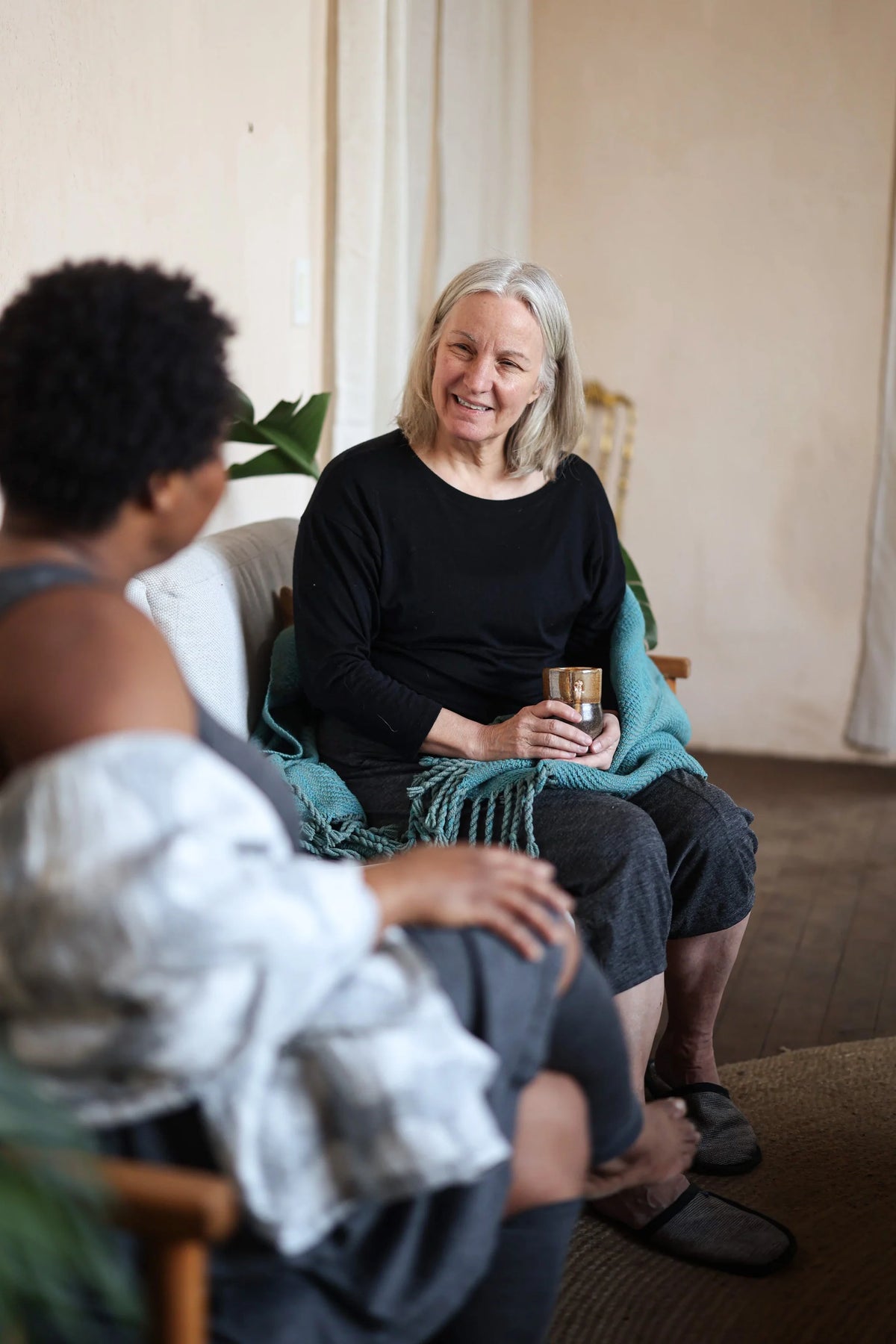 Woman wearing a merino wool lounge top during a relaxed wellness gathering, highlighting comfort and effortless style.