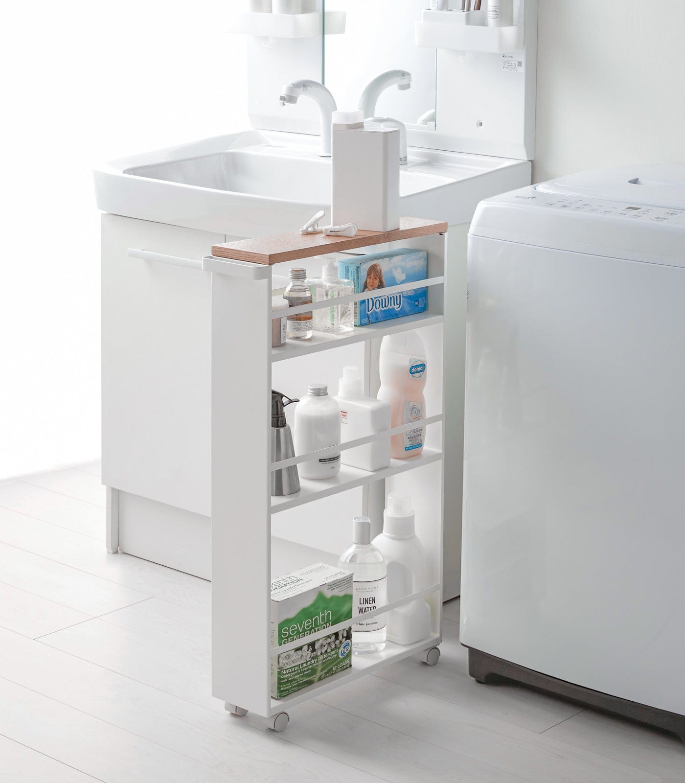 White rolling cart with shelves in a bathroom setting. Slim Storage Cart (32" H)  - Steel shown in laundry room