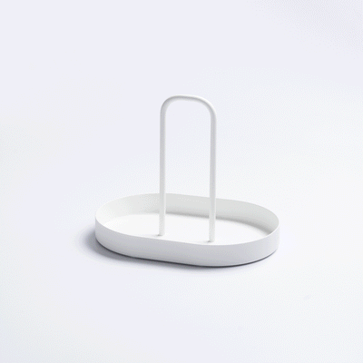 White Yamazaki Home Vanity Tray with Handle - Steel filled with upright green, cream and orange packets arranged around its central handle on a pale background.