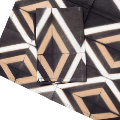 Close-up of folded Tisa napkins showing the sharp diamond shapes and hand-dyed color variations.