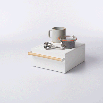 Yamazaki Home Countertop Rack with Drawer - Steel + Wood supporting a white gooseneck kettle, with the drawer open to reveal orange and green packets on a pale background.