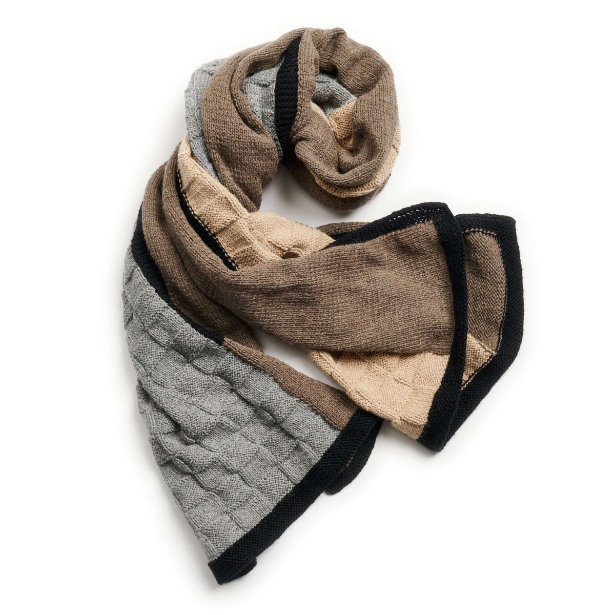 Loosely folded Muhu blanket showing its soft patchwork construction and contrasting black edging.