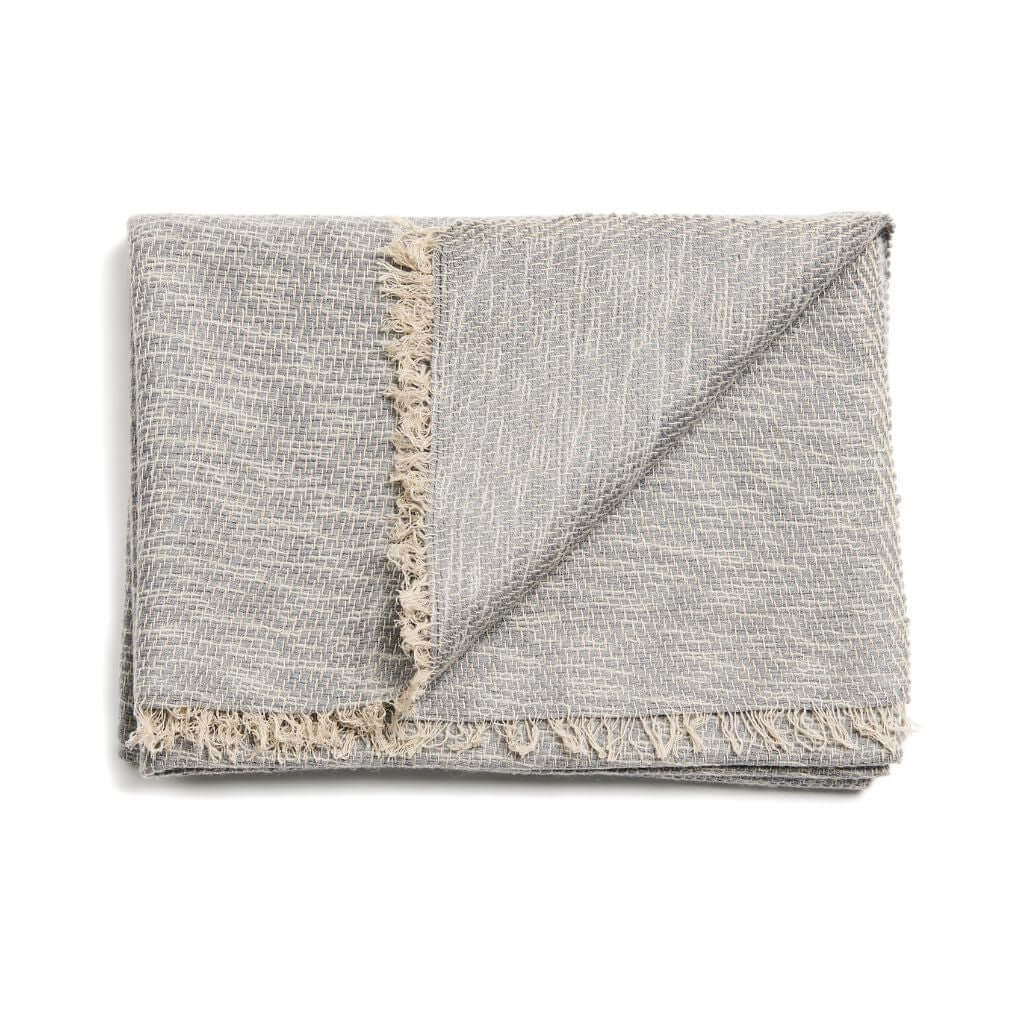 Folded gray color variation of the scarf with a contrasting fringed border.